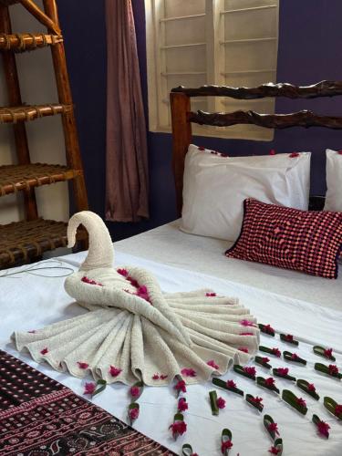 a swan towel on a bed with roses on it at Carpe Diem Nungwi in Nungwi