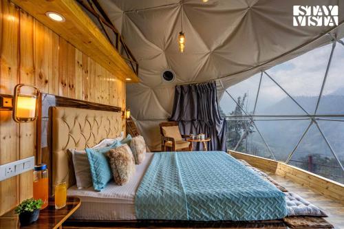 a bedroom with a bed in a tent at StayVista at The Stargazer with Mountain Views, Bonfire, Lawn in Pelling