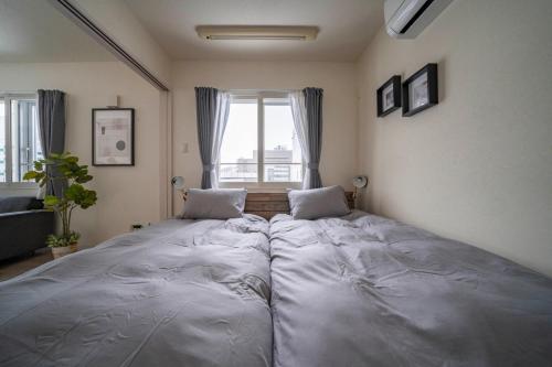 a large bed in a room with a large window at Court Villa Sapporo 503 in Sapporo