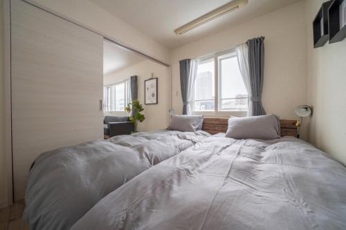 two large beds in a room with a window at Court Villa Sapporo 503 in Sapporo