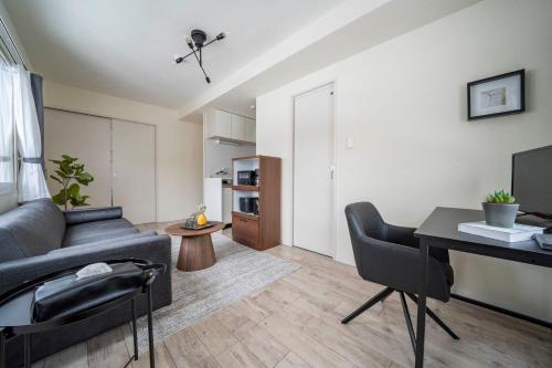 a living room with a couch and a table at Court Villa Sapporo 503 in Sapporo