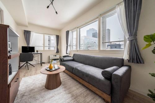 a living room with a couch and a table at Court Villa Sapporo 503 in Sapporo