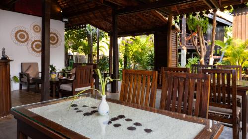 a table with a vase sitting on top of it at Khmer Lodge - Eco-Lodge in Phumĭ Réach Born