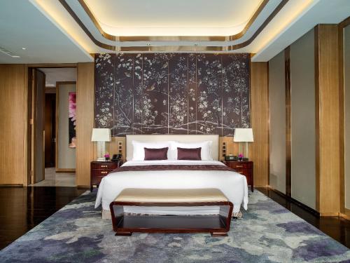 a bedroom with a large bed and a black wall at Kempinski Hotel Changsha in Changsha