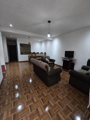 a large living room with couches and a piano at Casa Café in San Lucas Tolimán