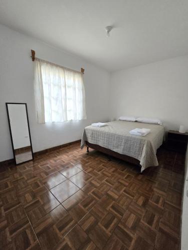 a bedroom with a bed and a wooden floor at Casa Café in San Lucas Tolimán