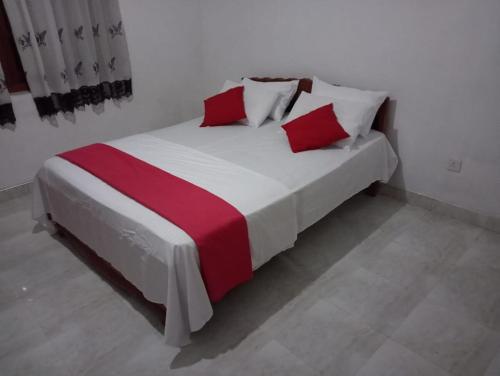 a bedroom with a large bed with red and white pillows at Rock View Bungalow - Home Stay - Kandy in Kandy