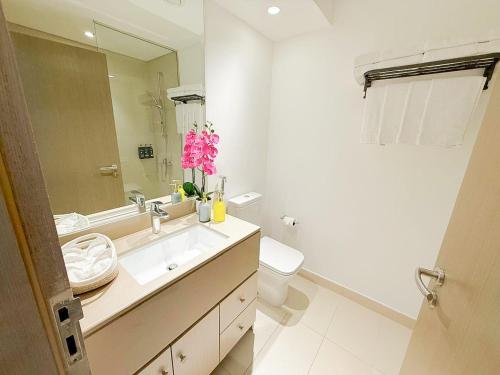 a bathroom with a sink and a toilet and a mirror at Yas Island Waters Edge Studio by Central Stay in Abu Dhabi