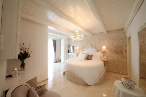 a bedroom with a white bed and a chandelier at Playa del Mar - Adults Only in Monopoli