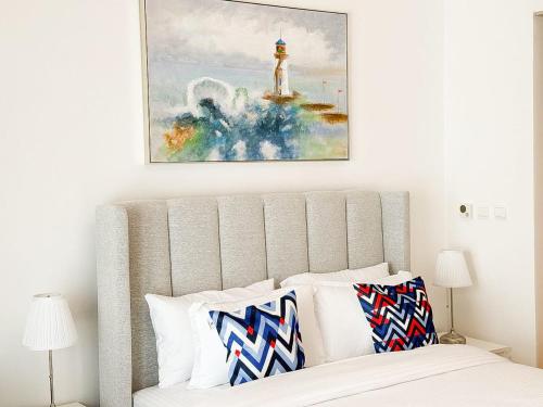a bedroom with a bed with a painting above it at Yas Island Waters Edge Studio by Central Stay in Abu Dhabi
