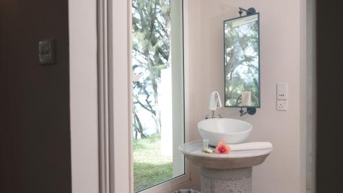 a bathroom with a sink and a mirror and a window at Andrea Lodges in Souillac