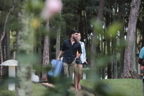 a man and a woman walking with a suitcase at Andrea Lodges in Souillac