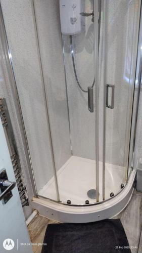 a shower with a glass door in a bathroom at Affordable 3 bed house Stoke-on-Trent for families and contractors in Stoke on Trent