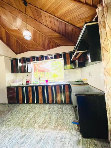a kitchen with wooden cabinets and a counter top at Gemlita Villa in Uswetakeiyawa in Bopitiya