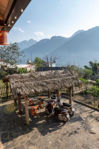 a group of motorcycles parked under a straw roof at Hmong Farmstay in Sa Pa