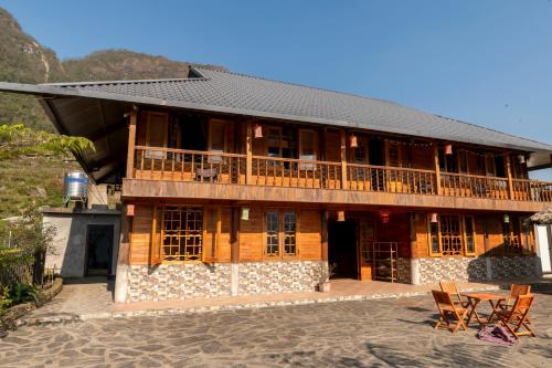 a wooden building with a balcony and two chairs at Hmong Farmstay in Sa Pa