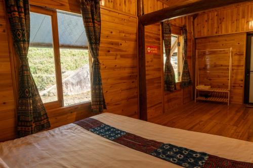 a bedroom with a bed in a wooden cabin at Hmong Farmstay in Sa Pa