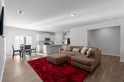 a living room with a couch and a red rug at Elegant Townhouse Retreat Near Mall Of Georgia in Buford