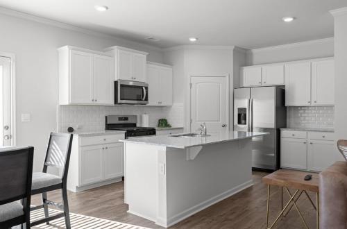 a kitchen with white cabinets and a counter top at Elegant Townhouse Retreat Near Mall Of Georgia in Buford