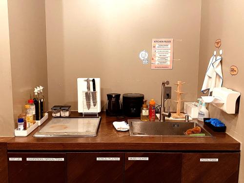 a kitchen with a sink and a counter top at &AND HOSTEL MINAMISENJU in Tokyo