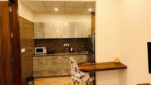 a kitchen with a wooden table and a chair at Liv Regalia Suites - Medanta Hospital, Sector 39, Gurgaon in Gurgaon