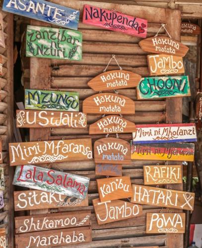 a wall of signs on the side of a building at Carpe Diem Nungwi in Nungwi