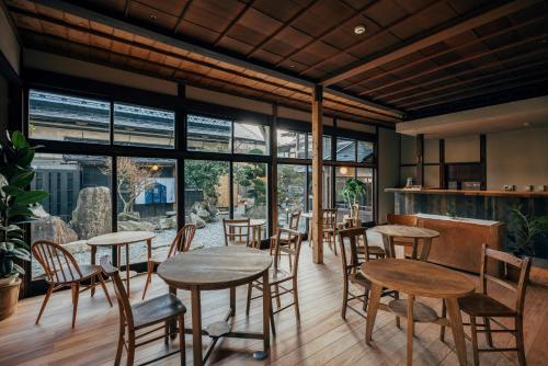 a restaurant with tables and chairs and large windows at 森長旅館 Moricho Ryokan in Oga