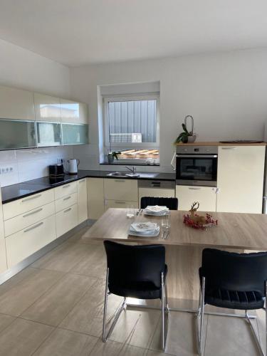 a kitchen with a wooden table and black chairs at Aarberg Lounge in Waldshut-Tiengen