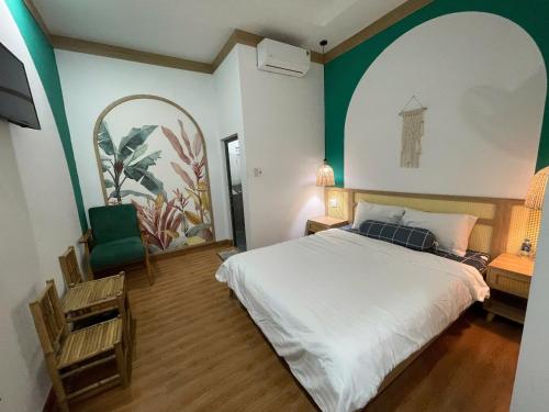 a bedroom with a white bed and a green wall at HomestayHoangYen in Phường Sáu