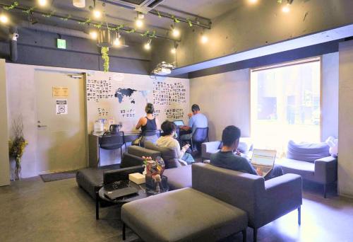 a group of people sitting in a waiting room at &AND HOSTEL MINAMISENJU in Tokyo