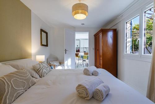 une chambre avec un grand lit blanc avec des serviettes dessus dans l'établissement La Petite Marjolaine Pretty Garden Level in Vence, à Vence