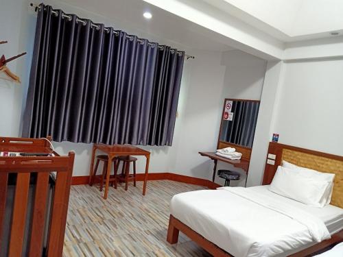 Postel nebo postele na pokoji v ubytování โรงแรมบ้านนายถึกและร้านอาหาร