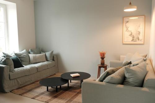 un salon avec deux canapés et une table dans l'établissement Maison rénovée à 80m de la plage, charme et confort, à Saint-Jacut-de-la-Mer