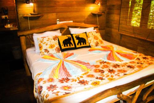a bed with a comforter with flowers on it at Lotus Eco Villa in Sigiriya