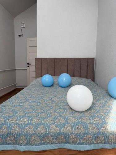 a bed with blue pillows on top of it at Абая 29 гостевые домики in Kosh-Tegirmen