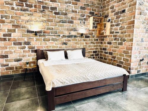 a bed in a room with a brick wall at Modern apartments with a coffee machine in the city center, a view of the city in Rivne