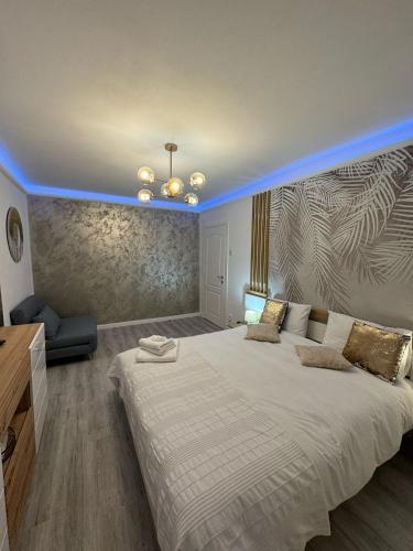 a bedroom with a large white bed with a blue lighting at Sara Suite in Sibiu