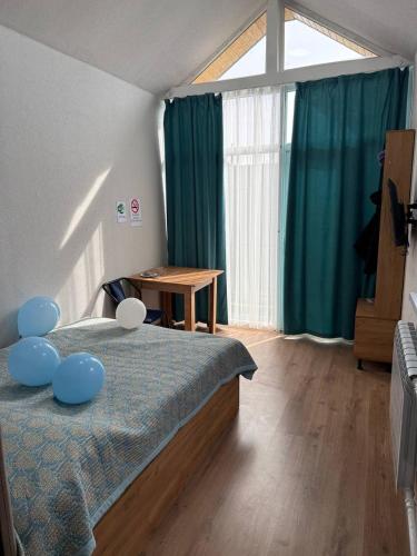 a bedroom with a bed with blue pillows on it at Абая 29 гостевые домики in Kosh-Tegirmen