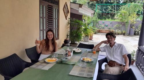 a man and woman sitting at a table with a baby at The Vitamin Sea in Ambalangoda