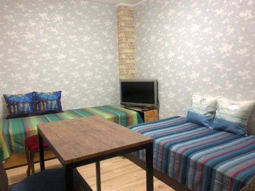 una stanza con un letto, un tavolo e una tv di BlueHouse a Hiroshima