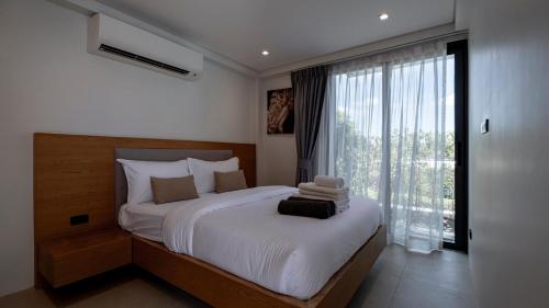 a bedroom with a large bed and a large window at Luxury Modern Loft Villa Riverhouse in Laguna Phuket