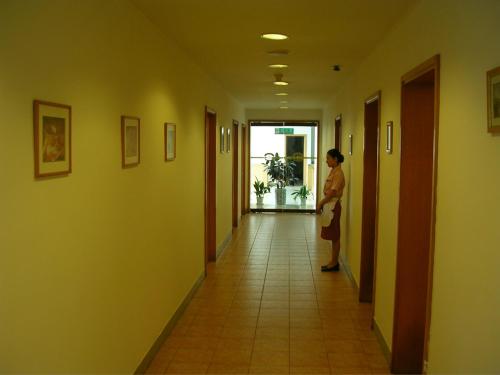 a woman walking down a hallway in a building at Jinjiang Inn Shenyang North Railway Station Huigong Square in Shenyang