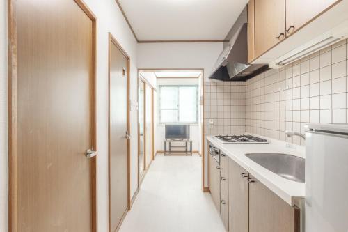 a small kitchen with a sink and a stove at Uhome Haneda Apartment in Tokyo
