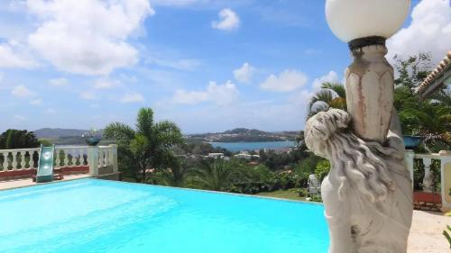 a statue next to a swimming pool at Maison avec vue sur la mer à La Trinité, piscine partagée in La Trinité