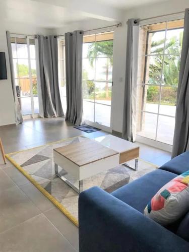 a living room with a blue couch and a coffee table at Maison avec vue sur la mer à La Trinité, piscine partagée in La Trinité