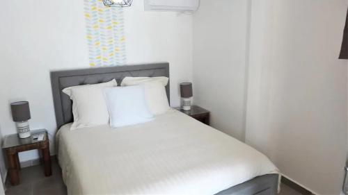 a bedroom with a white bed with two night stands at Maison avec vue sur la mer à La Trinité, piscine partagée in La Trinité