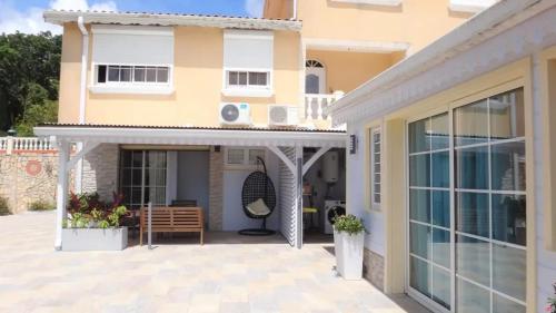a house with a patio in front of it at Maison avec vue sur la mer à La Trinité, piscine partagée in La Trinité