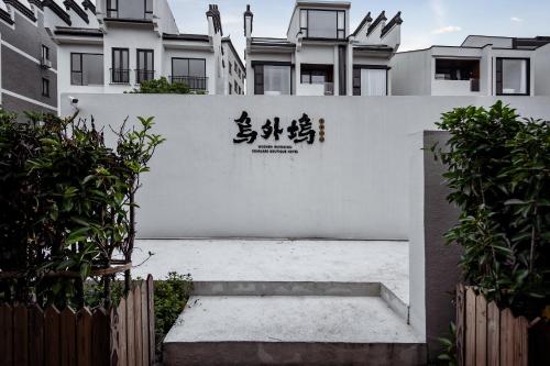 un muro bianco con scritte asiatiche sopra di 乌镇乌外坞酒店 a Tongxiang