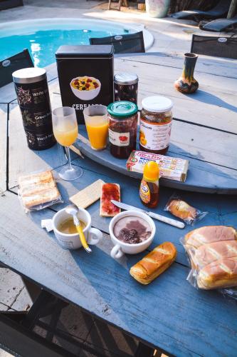 een blauwe picknicktafel met eten, drinken en brood bij La yourte de Nîmes, sauna, spa , jacuzzi piscine et aire de jeux privatif in Caveirac
