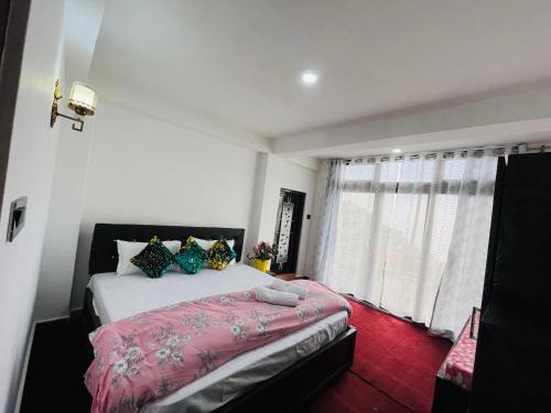 a bedroom with a large bed and a window at shalom inn home stay in Darjeeling